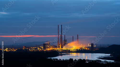 Industry or power plant during early sunrise with steam or smoke rising
