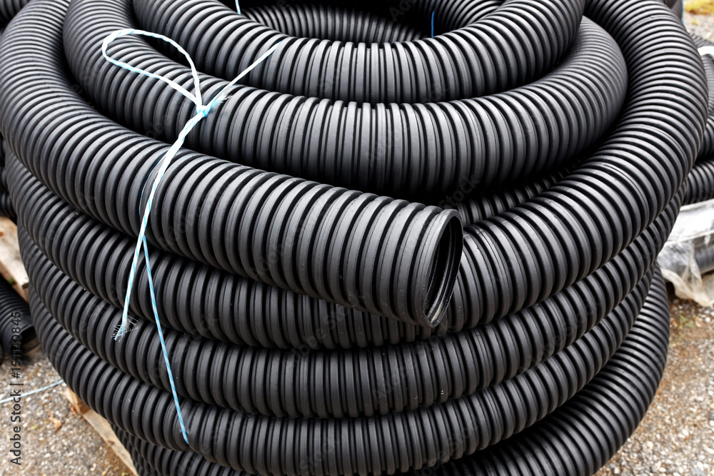 Coiled and stacked drainage tubing. Stock Photo | Adobe Stock