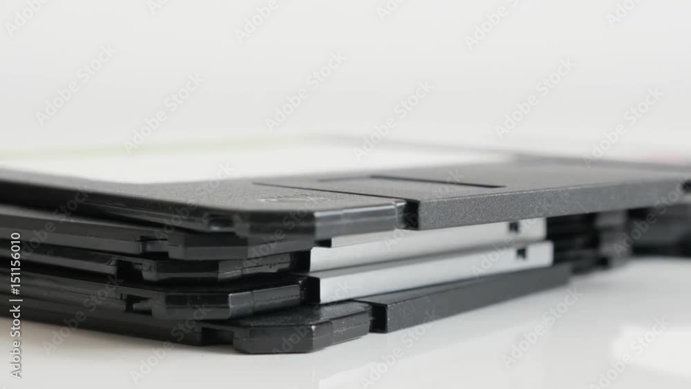 Lot of diskette data archives stacked 4K 2160p 30fps UHD tilting footage - Black floppy disc classic magnetic storage media on white 3840X2160 UltraHD video Lot of diskette data archives stacked 4K 2160p 30fps UHD tilting footage - Black floppy disc classic magnetic storage media on white 3840X2160 UltraHD video