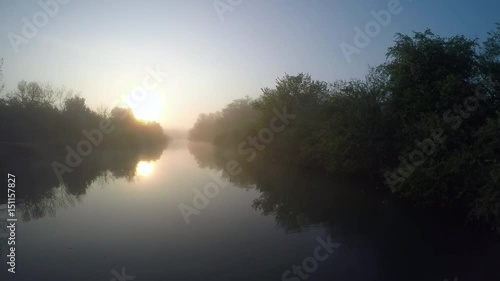 4K: Aerial Sun rising over misty river in marsh