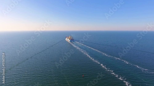 Aerial view of container ship floats in the open ocean after loading in the port of China at full speed. 4K.