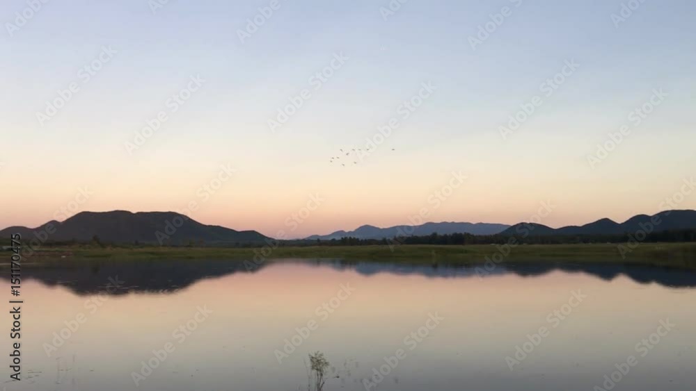 Sunset in twilight time behind the mountains front water of a reservoir. Sunset in twilight time behind the mountains front water of a reservoir.