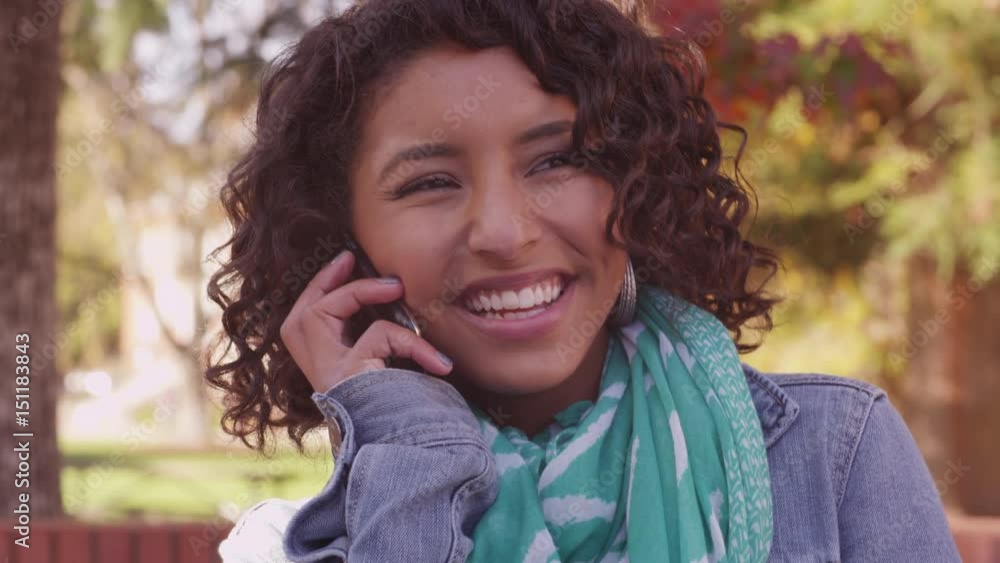 College student on campus in fall talking on cell phone College student on campus in fall talking on cell phone