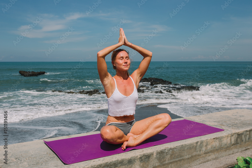 Girl practicing yoga on the beach in the morning time Girl practicing yoga on the beach in the morning time