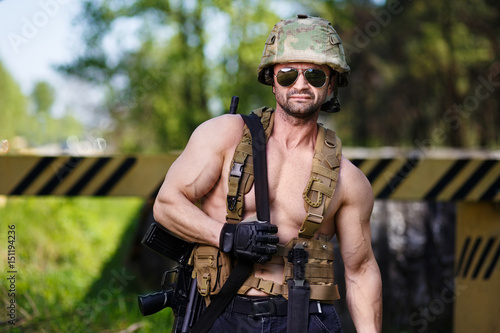Bilde på lerret Powerful mercenary with submachine gun guarding a roadblock