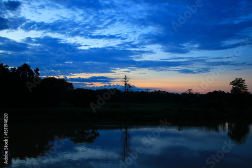 sky in sunset cloud colorful beautiful with silhouette tree woodland and river reflect in countryside evening on nature