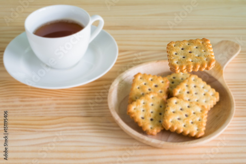 Chocolate cream biscuit levitate in mid air with the tea cup in the background