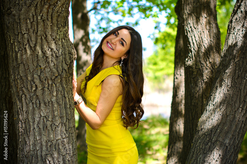 Charming Latin girl in a yellow short dress with a good mood resting on vacation and enjoying life laughing and smiling