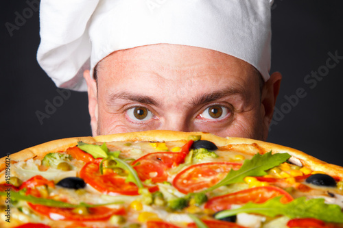 фотографія Portrait of happy attractive cook with a pizza