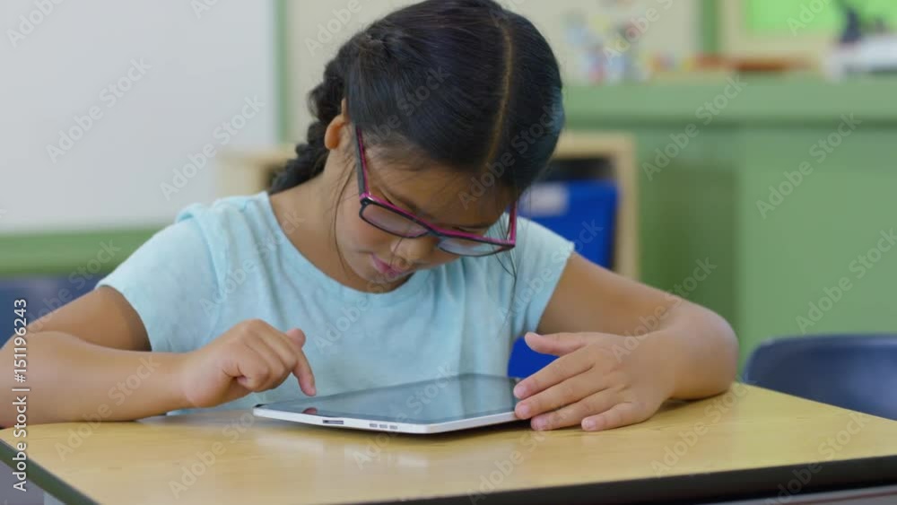 Young girl in school classroom using digital tablet Young girl in school classroom using digital tablet