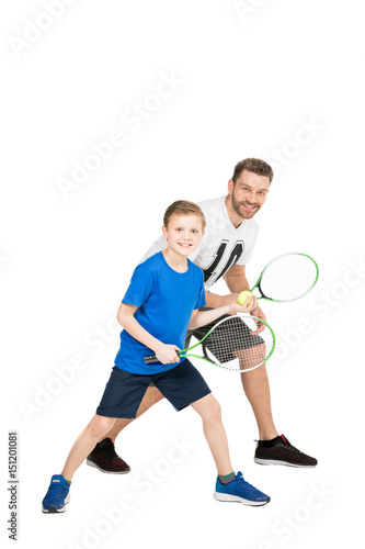 side view of active father and son with tennis racquets isolated on white © LIGHTFIELD STUDIOS