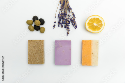 Top view of three types on homemade soap with dried lavender, olives and lemon isolated on white