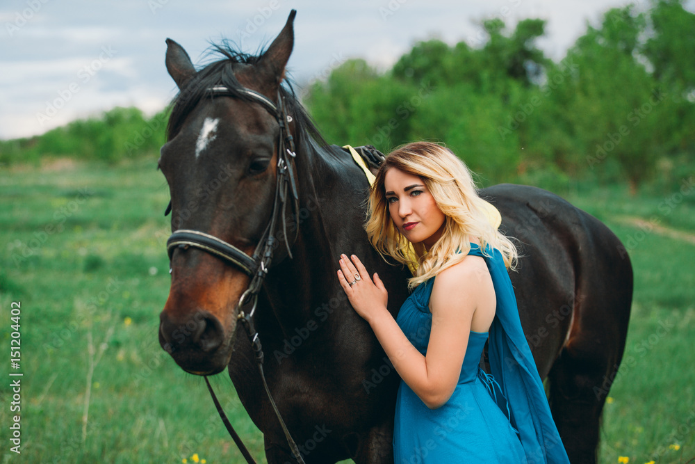 Obraz premium Girl in meadow with a horse on green grass