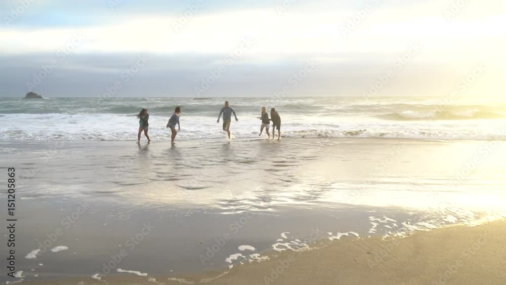 Group of friends at beach playing in surf Group of friends at beach playing in surf