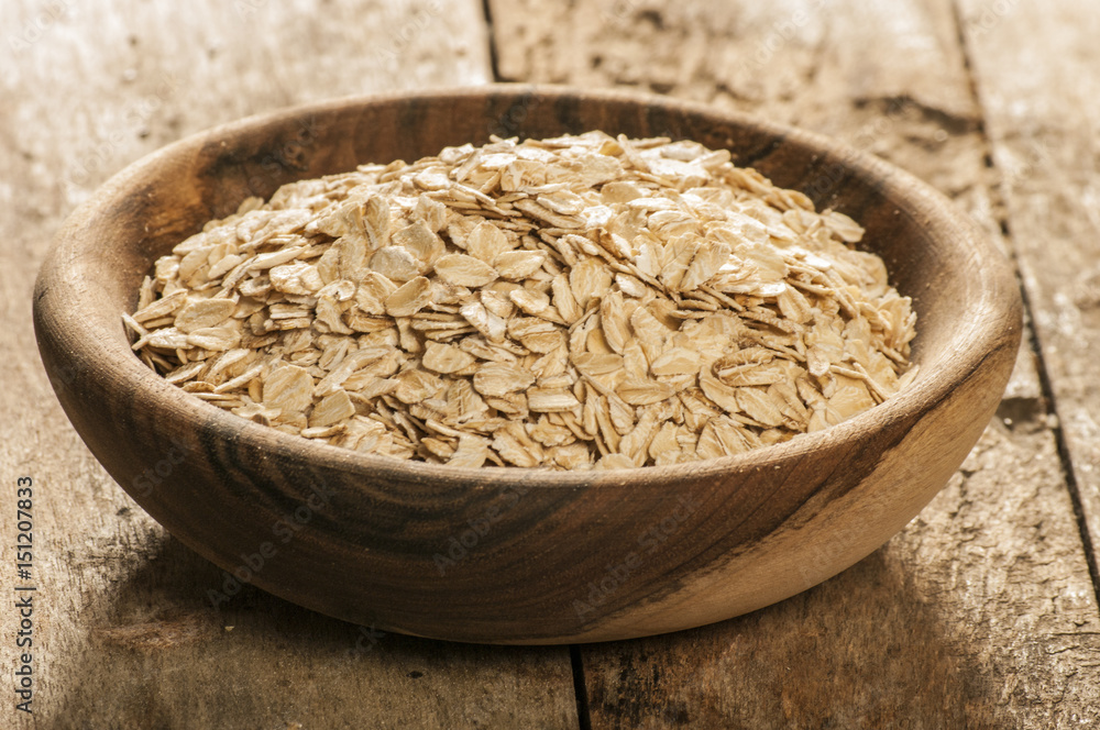Plate with raw oatmeal on wooden table. Plate with raw oatmeal on wooden table.