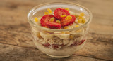 Oatmeal with banana, strawberry and glass of milk on brown wooden table