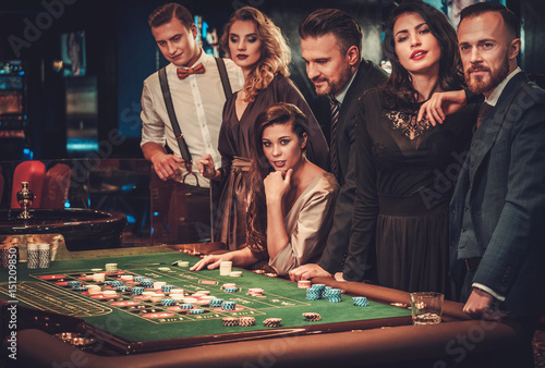 Upper class friends gambling in a casino photo