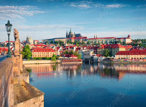 Colorful morning view of Charles Bridge, Prague Castle and St. Vitus cathedral on Vltava river photo