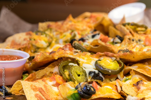 Foto Large nacho plate smothered with cheese and jalapeno peppers