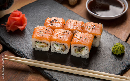 Sushi rolls, maki, nigiri Set served for two on black stone slate on dark background