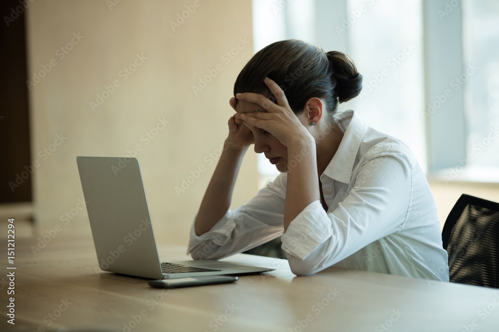 Worried female business executive using laptop Worried female business executive using laptop