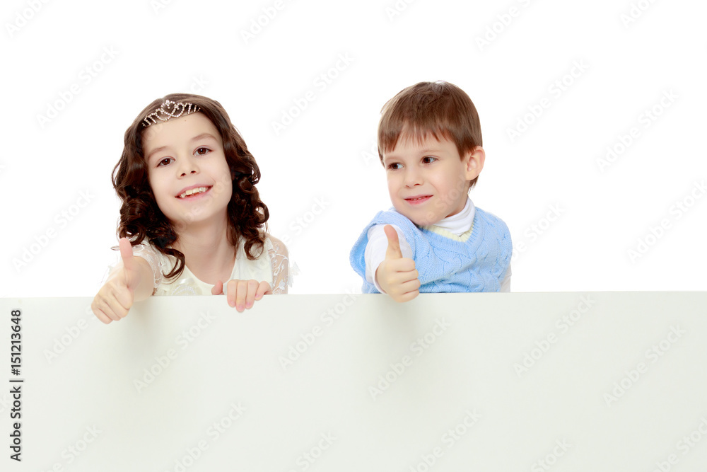 Children look out from behind the banner. Children look out from behind the banner.