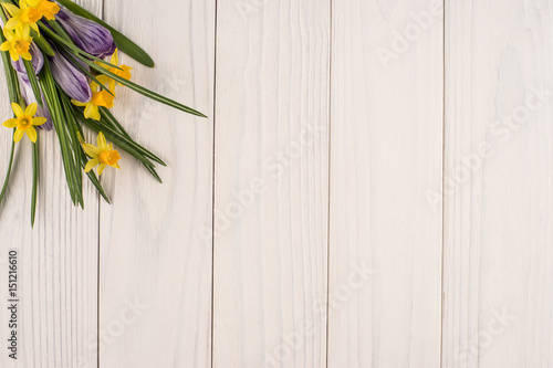 Fototapeta Naklejka Na Ścianę i Meble -  Daffodils and crocuses on the old white wooden table.