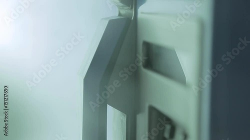 Close-up of person hanging up pay phone receiver. Night photo