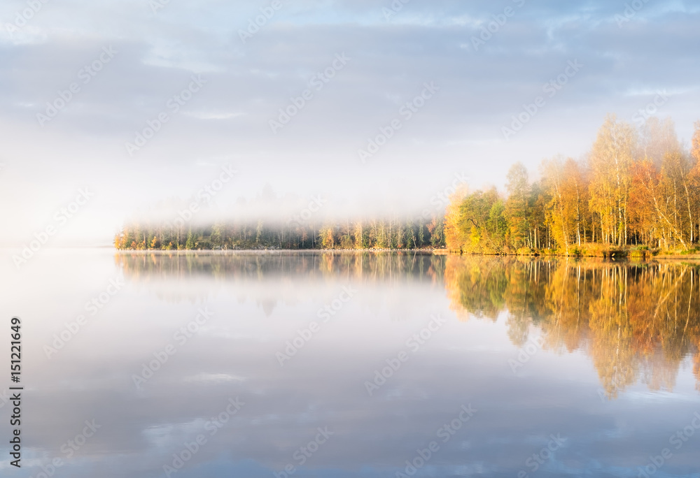 Scenic landscape with lake and fall colors at morning light in Finland