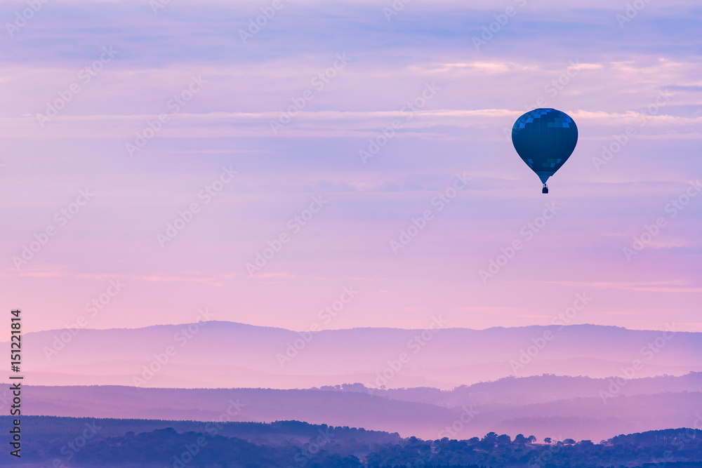 Hot Air Balloon Floating Over The Mountains In The Twilight