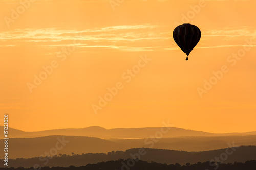 Hot Air Balloon Floating Over The Mountains In The Twilight