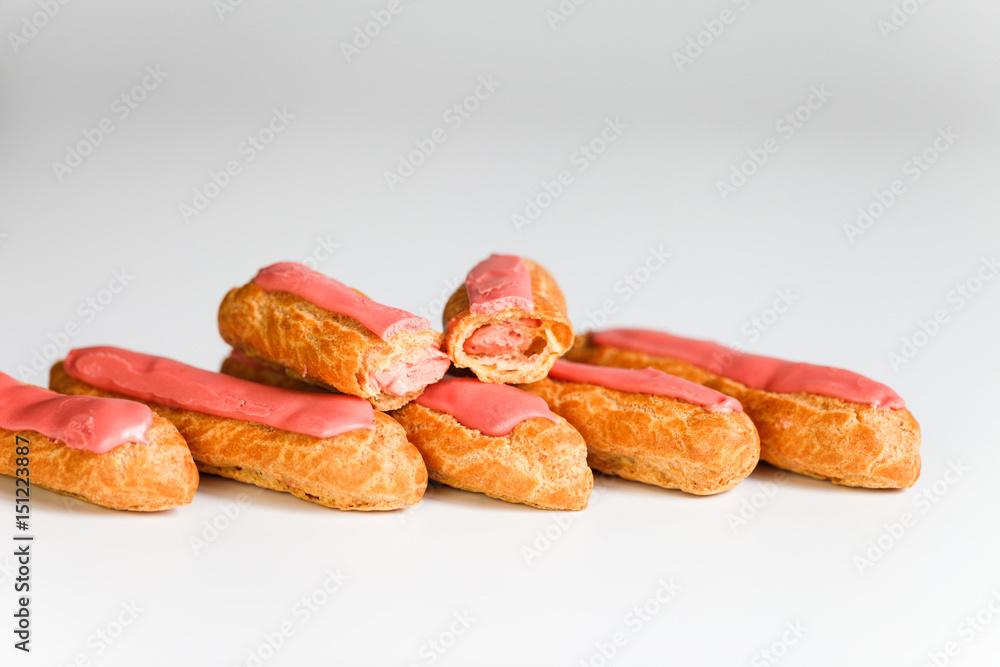 Pink icing Eclairs on white backgound 