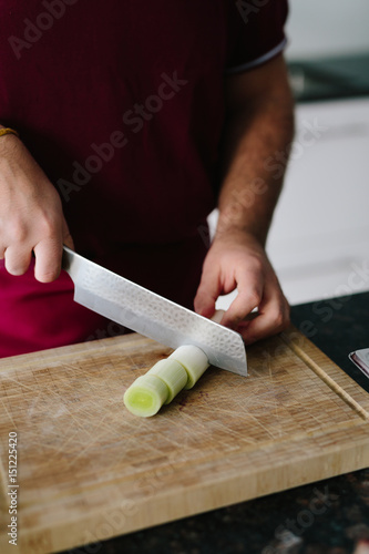 Man is cutting garlic leek