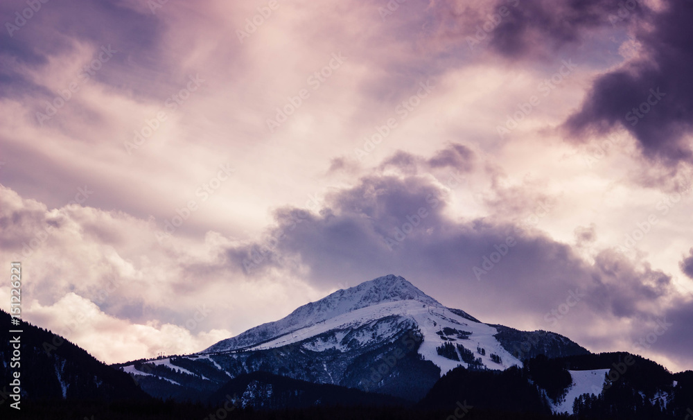Photo depicting a beautiful moody frosty landscape European alpine mountains with snow peaks on a blue sky background.