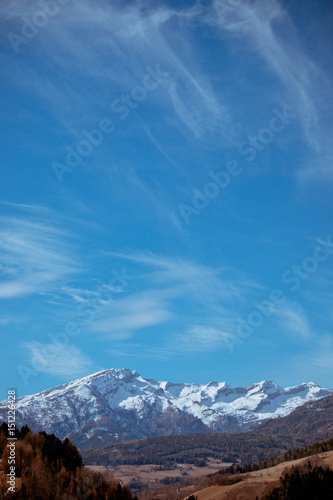 Photo depicting a beautiful moody frosty landscape. European alpine mountains with snow peaks on a blue sky background. © alicefoxartbox