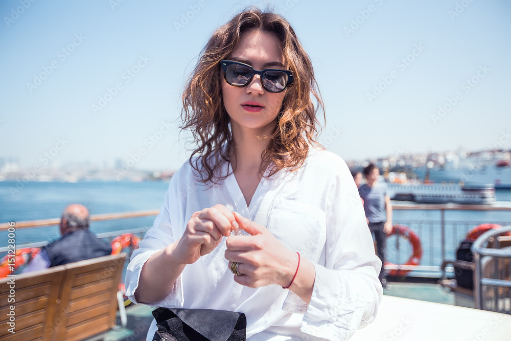 beautiful Woman uses perfume on the sea terrace