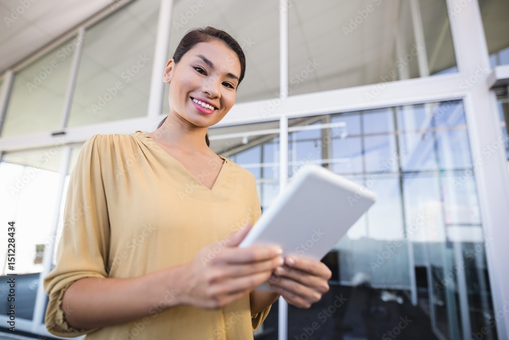 Portrait of smiling businesswoman using tablet in office Portrait of smiling businesswoman using tablet in office