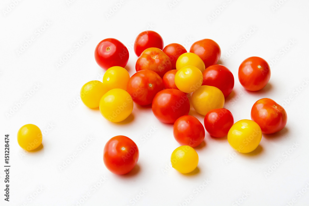 Red and yellow cherry tomatoes on a white background. Red and yellow cherry tomatoes on a white background.
