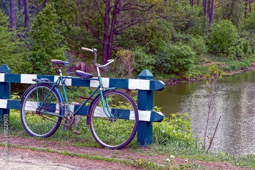 Старый велосипед возле ограждения на берегу водоёма