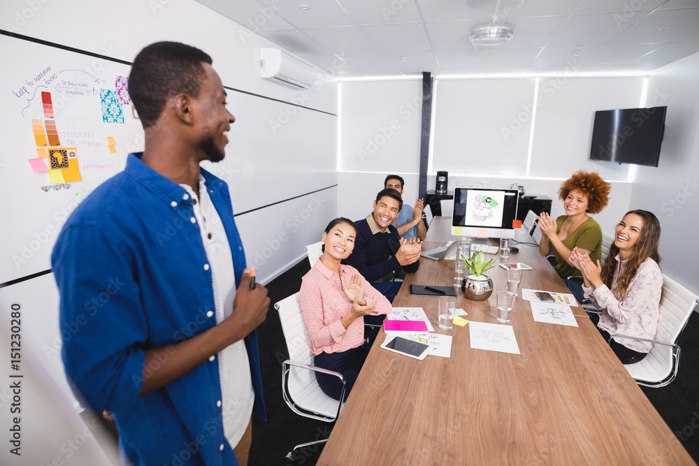 Obraz premium Colleagues clapping after presentation at creative office