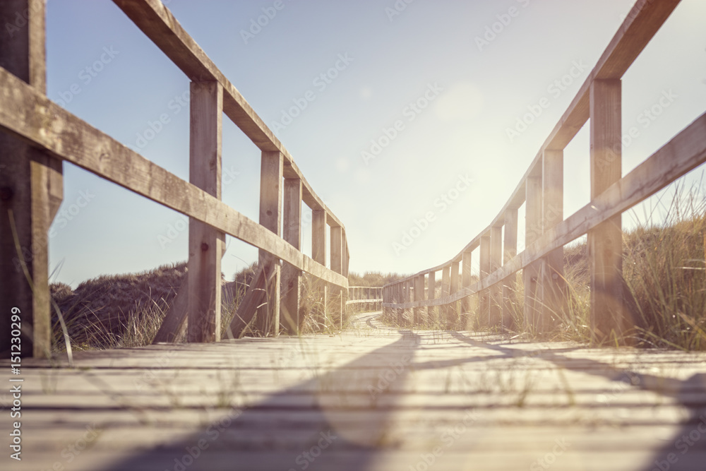 Fototapeta premium Boardwalk leading to the beach over sand dunes