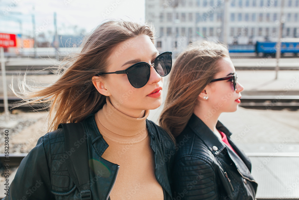 Beautiful fashion women posing. Trendy lifestyle urban portrait on city background. Girls wearing in style clothes and accessories Beautiful fashion women posing. Trendy lifestyle urban portrait on city background. Girls wearing in style clothes and accessories