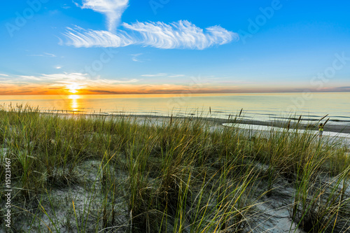 Fototapeta Naklejka Na Ścianę i Meble -  Sandy beach and sunset sky with golden sun shining on white sand