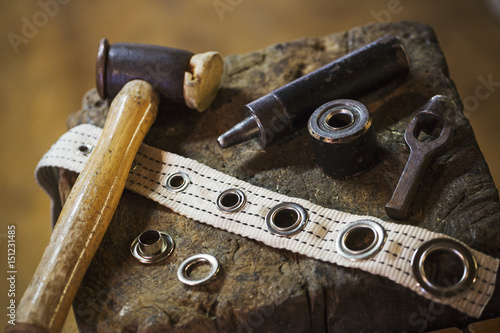 Close up of tools and eyelets in a sailmaker's workshop.