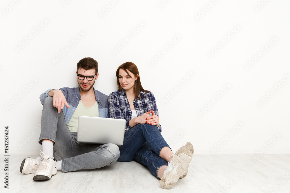 Couple web-surfing with laptop in empty room