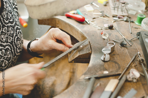 Cropped image of senior craftsperson making jewelry in workshop photo