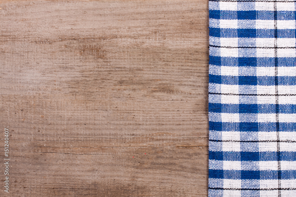 Blue checkered tablecloth on old wooden table with copy space for your text. Top view Blue checkered tablecloth on old wooden table with copy space for your text. Top view