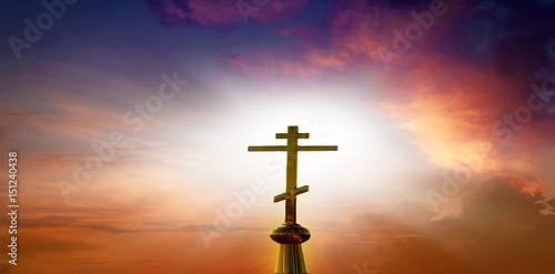 Sunset sky . Cross against the background of a decline. Divine light in clouds . colourful sky . God's Cross .