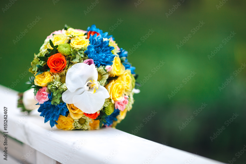 Wedding summer bouquet on wooden white railing, on a green background