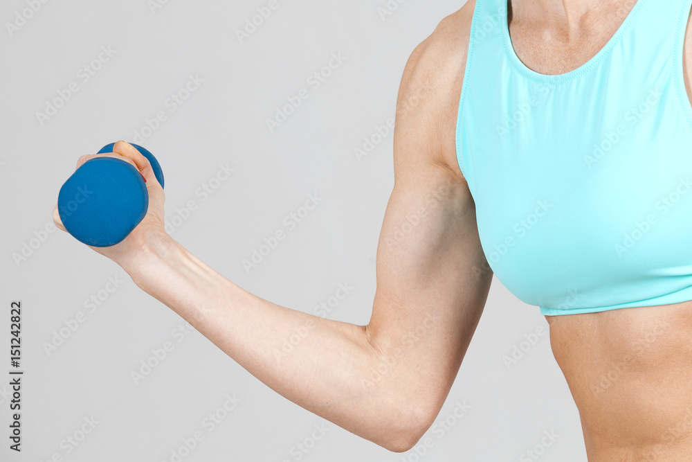 strong hand is  trained by dumbbell on the grey background